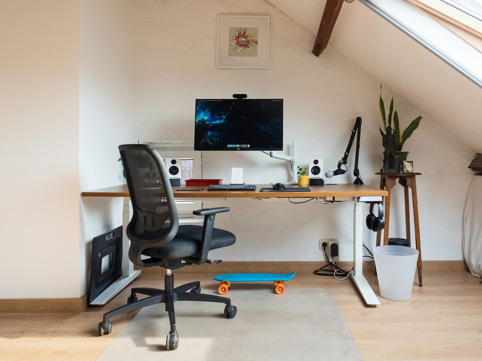 Arbeitsplatz im Homeoffice mit Monitor, Steckdosenleiste und Kabeln unter dem Schreibtisch